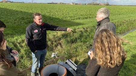 beeld van personen rondom zichtbaar deel van de drainage proef